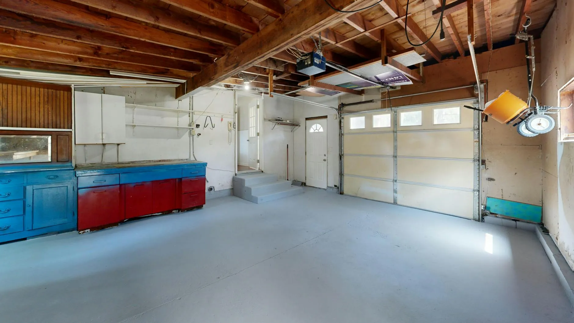 Intérieur de garage rangé avec une porte enroulable ouverte